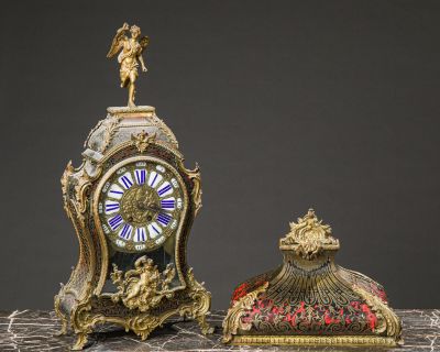 a small clock sitting next to a smaller clock on a table