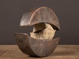 une photo représentant une sculpture en bois représentant un coquillage posée sur une table en bois