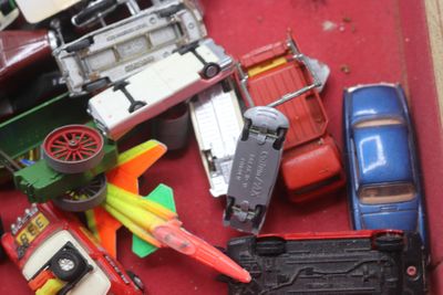 une boîte rouge remplie de petites voitures et d'autres véhicules miniatures