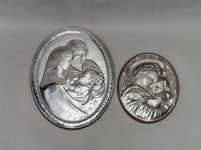 deux médaillons en argent représentant un homme et une femme tenant un bébé dans leurs bras