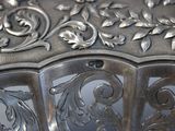 a close up of a silver plate with a design on it