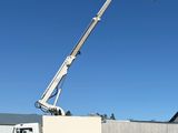 a white bucket truck with a crane on the back of it