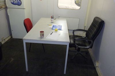 une table blanche avec une chaise rouge et une chaise noire