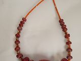 necklace made of red coral beads and orange glass beads on a string