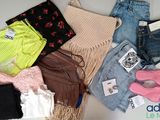 many different types of clothes and bags laid out on a table