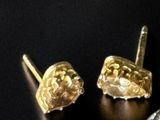 pair of gold and diamond earrings on a black surface