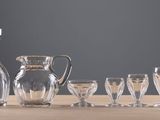 bottles and glasses are lined up on a wooden table
