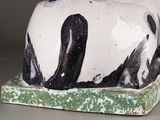 a black and white cat sitting on a green and white box