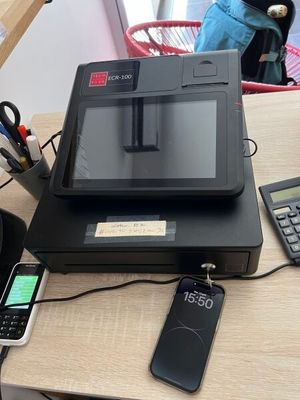 an image of a cash register and a cell phone on a desk