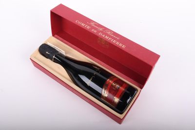 une bouteille de vin dans un coffret rouge posée sur une surface blanche