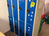 Plusieurs casiers bleus sont empilés dans une pièce où se trouvent des cartons par terre.