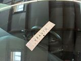 a sticker on the windshield of a car with a name tag attached to it
