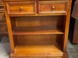 une bibliothèque en bois surmontée de deux tiroirs