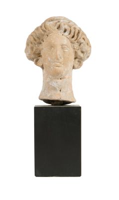 une tête de femme antique posée sur un socle noir