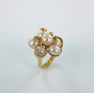 une bague en or ornée de perles et de diamants sur fond blanc
