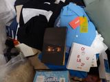 a pile of clothing and books on a bed