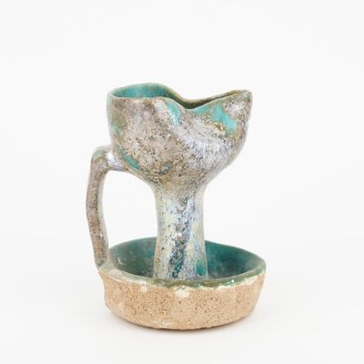 a small cup with a handle on a saucer