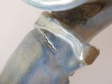 a close up of a blue vase with a bird on top of it