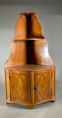 une vieille armoire d'angle en bois à deux portes et une étagère