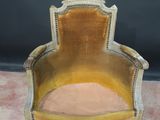 an old chair with a yellow velvet upholstered seat