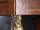 a brass head on the top of a wooden cabinet