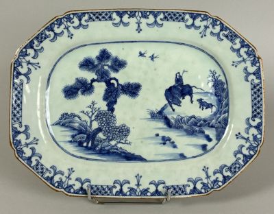 a blue and white plate with a picture of a man riding a horse