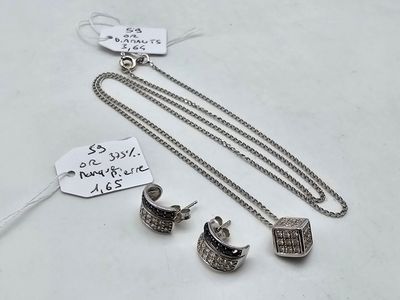 deux bijoux en argent posés sur une table blanche