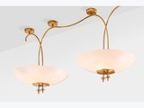 a pair of brass plated wall lights with frosted glass shades