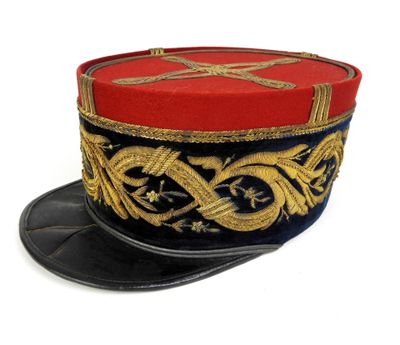 un chapeau rouge et bleu orné de décorations dorées