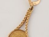 une image représentant un porte-clés en or orné d'une pièce de monnaie