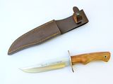 a knife that is sitting next to a leather sheath