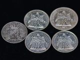 six pièces de monnaie britanniques différentes empilées les unes sur les autres sur une surface noire
