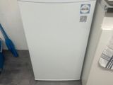 a small white refrigerator next to a sink in a kitchen