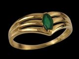 a close up of a gold ring with a green stone