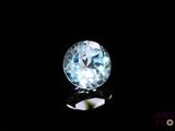 un gros plan d'une topaze bleue et d'un diamant sur une surface noire