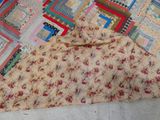 a patchwork quilt on the ground with a cat sleeping on it