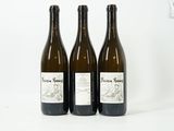 trois bouteilles de vin posées les unes à côté des autres sur une surface blanche