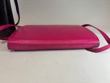 a pink purse sitting on top of a table next to a black bag