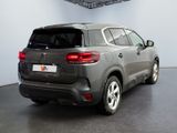 the rear end of a grey suv parked in a garage