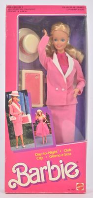 une poupée Barbie vêtue d'un tailleur rose et d'un chapeau, avec un sac à main rose
