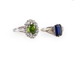 deux bagues ornées de pierres de couleurs différentes et de diamants sur fond blanc