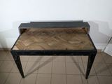 a small wooden table with a metal top on a tiled floor