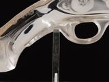 a glass gun on a stand on a black background