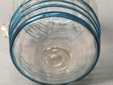 a clear glass jar with a blue band around it