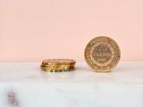 two gold coins sitting on top of a marble counter