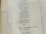 an open book with a handwritten poem on it