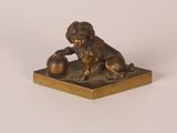 bronze figurine of a lion with a ball in its paws