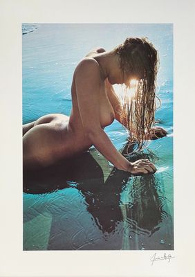 an image of a nude woman laying on a surfboard in the water