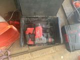 a box with a drill and other tools on the floor
