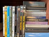 a book shelf with many dvds on top of it